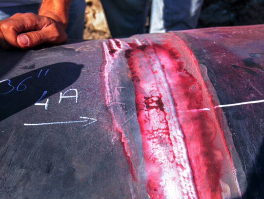 View of the cracks on the welded pipe after liquid penetrant test.